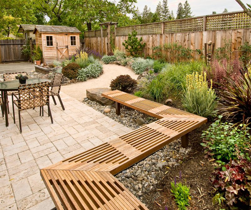 stone patio with wooden bench and fence