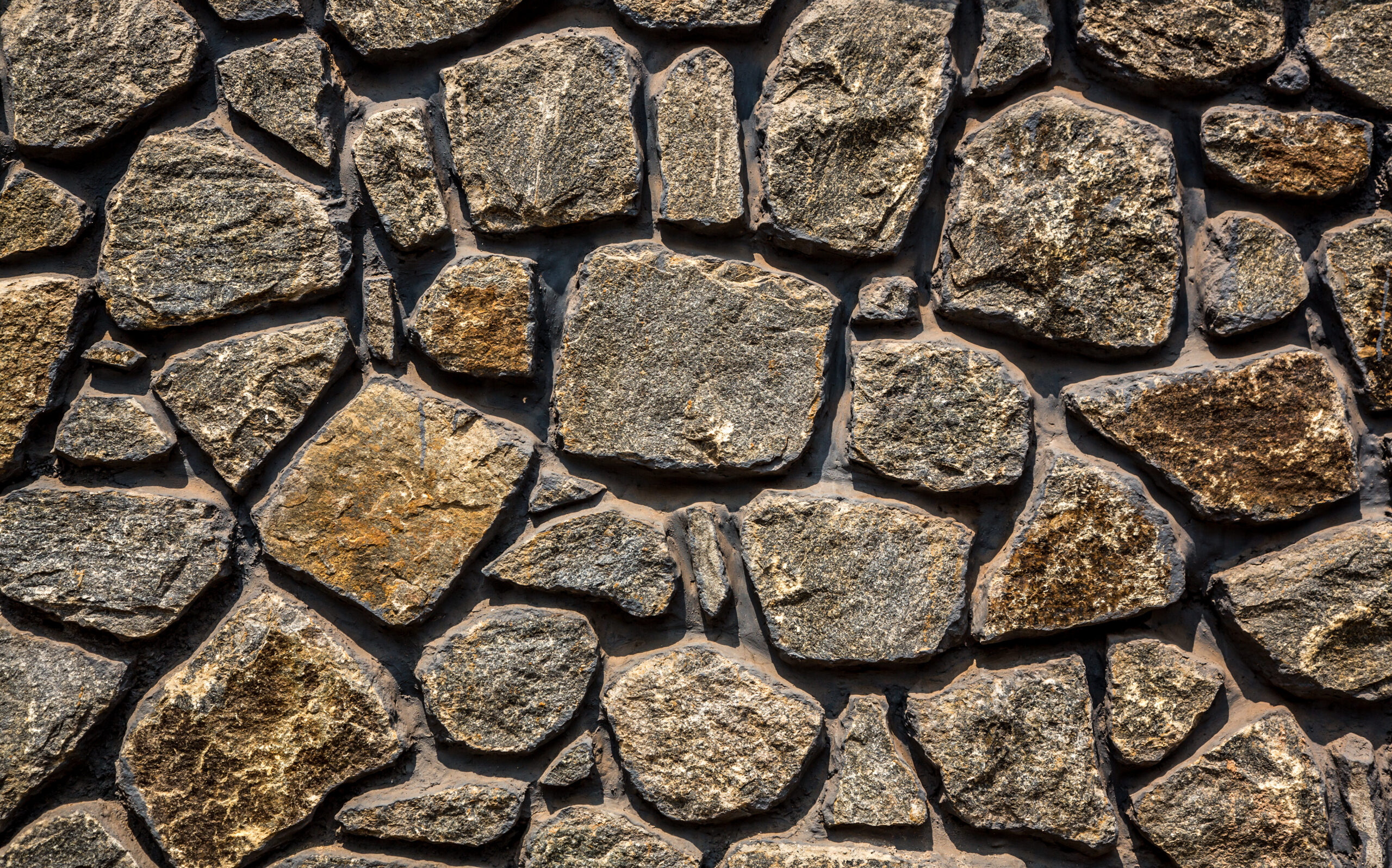 Background image of gray uncoursed stone masonry wall